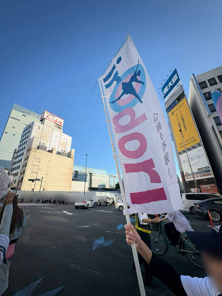 パレード時に撮影された青空に映えるirOdoriフラッグ。